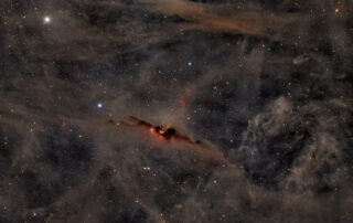 The Red Glow of the Cosmic Bat Nebula